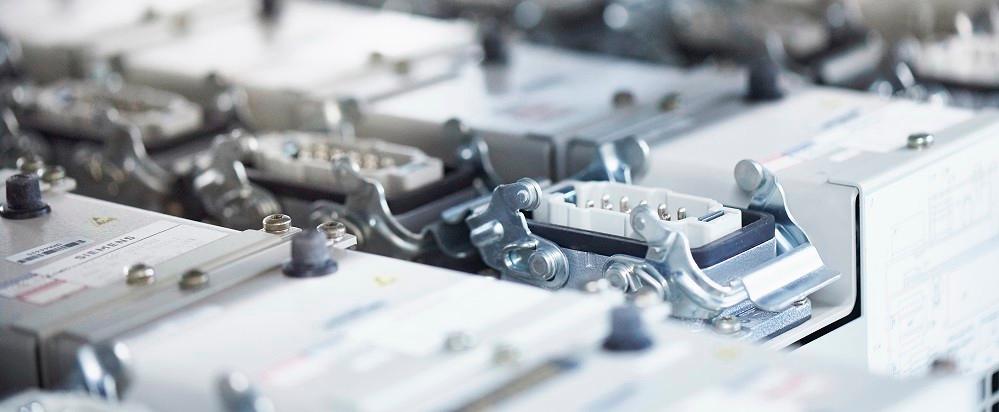 Close-up of industrial electronic modules with multi-pin connectors and metal mounting hardware.